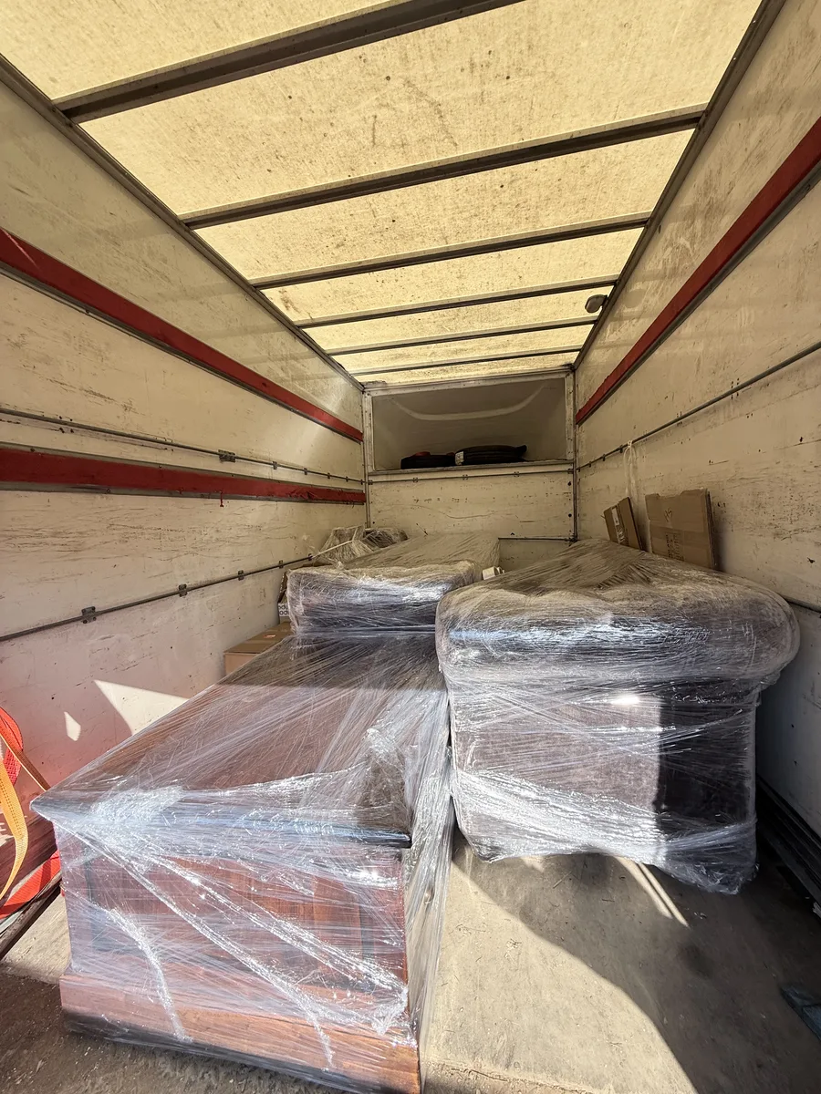 Pracownik Wasiewicz zabezpiecza meble w busie transportowym